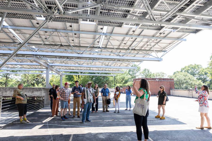 group of people on a tour under solar array